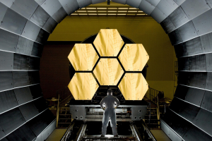 Photo of man in front of large optics.