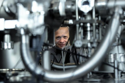 Photo of Professor Aleksander Jablonski looking through a gap in the instrument