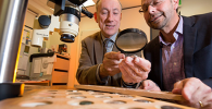 Associate Professor Kenneth Sheedy and Dr Gil Davis examine ancient coins. Photo of Kenneth Sheedy and Gil Davis examining ancient coins.