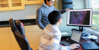 Photo of Zhe Zhu and graduate student working in the lab